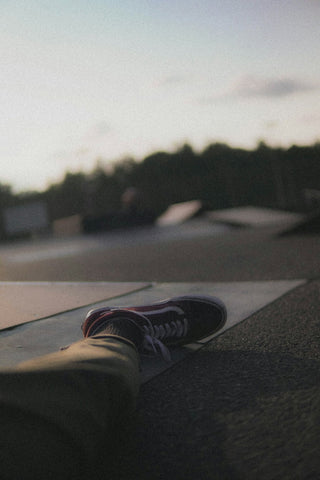 person in brown pants wearing black and white sneakers