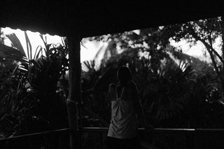 a person standing in front of a window looking at a large fish tank